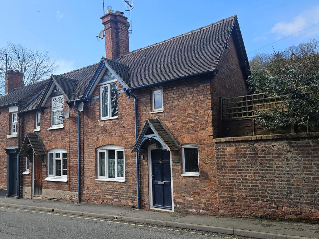 a red brick house with a black roof at Katie's Cottage in Church Stretton