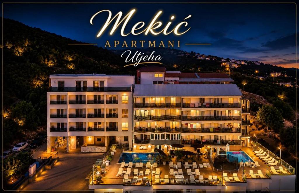 a hotel with a pool in front of a building at Apartments Mekic in Utjeha