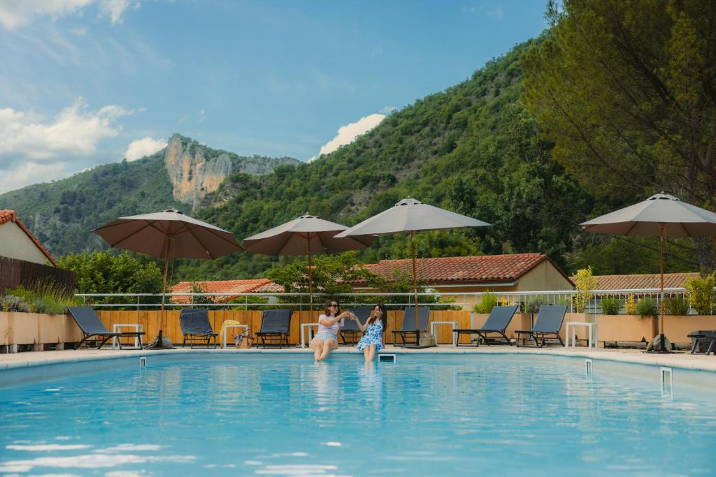 a woman and child in the swimming pool at a hotel at Hôtel Le Refuge des Sources in Digne-les-Bains