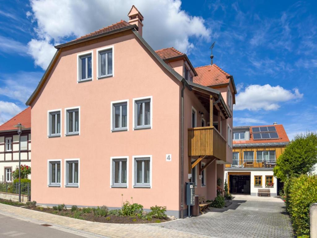 a pink house with a brown roof at Ferienwohnung Binder - Ferienwohnung Bad Windsheim in Bad Windsheim