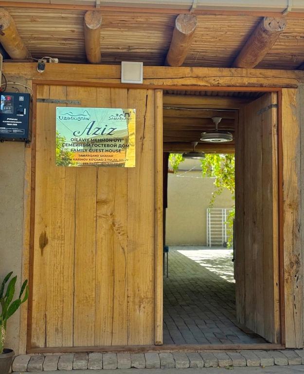 a wooden entrance to a building with a sign on it at Aziz Guest House in Samarkand