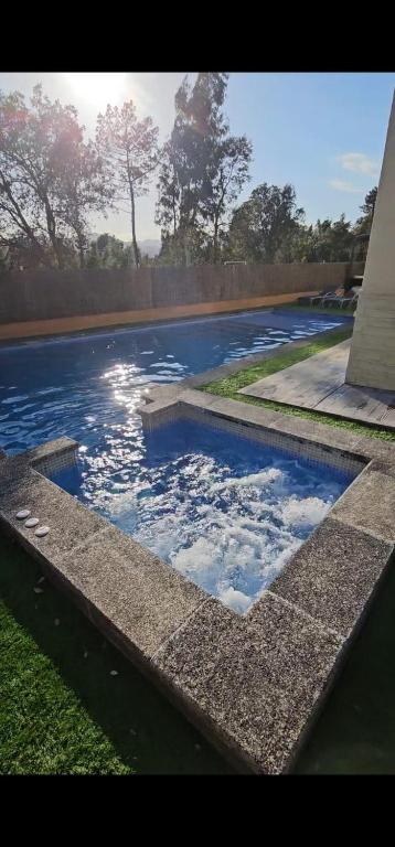 a swimming pool with blue water in a yard at Villadora Piscina privada & jacuzzi Cerca de la costa brava in Santa Coloma de Farners