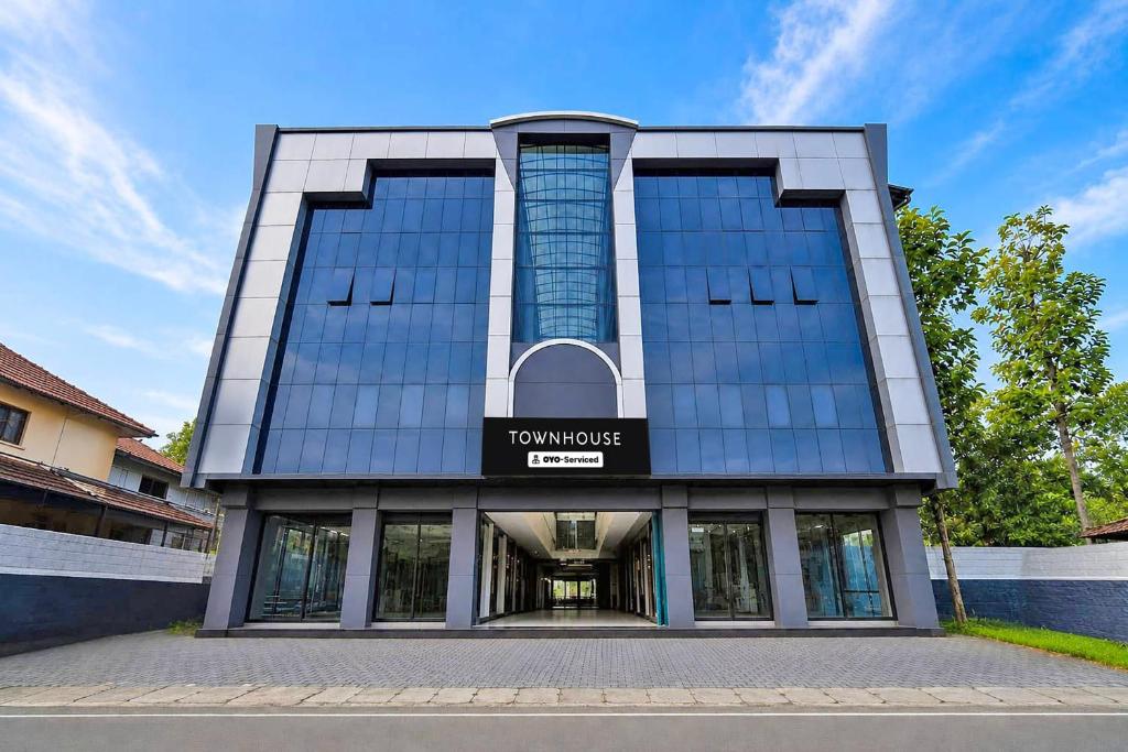 a tall building with a sign on the front of it at Townhouse Kozhencherry Formerly The Beige Hotel in Pathanāmthitta