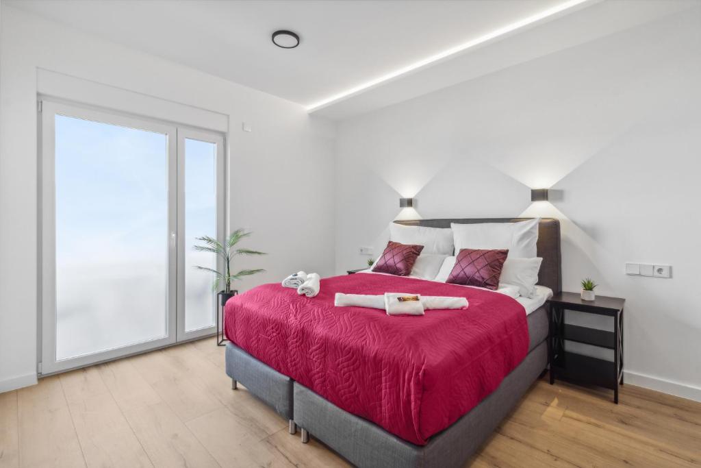 a bedroom with a large bed with a red blanket at Hotel Suite4Me Dietzenbach in Dietzenbach