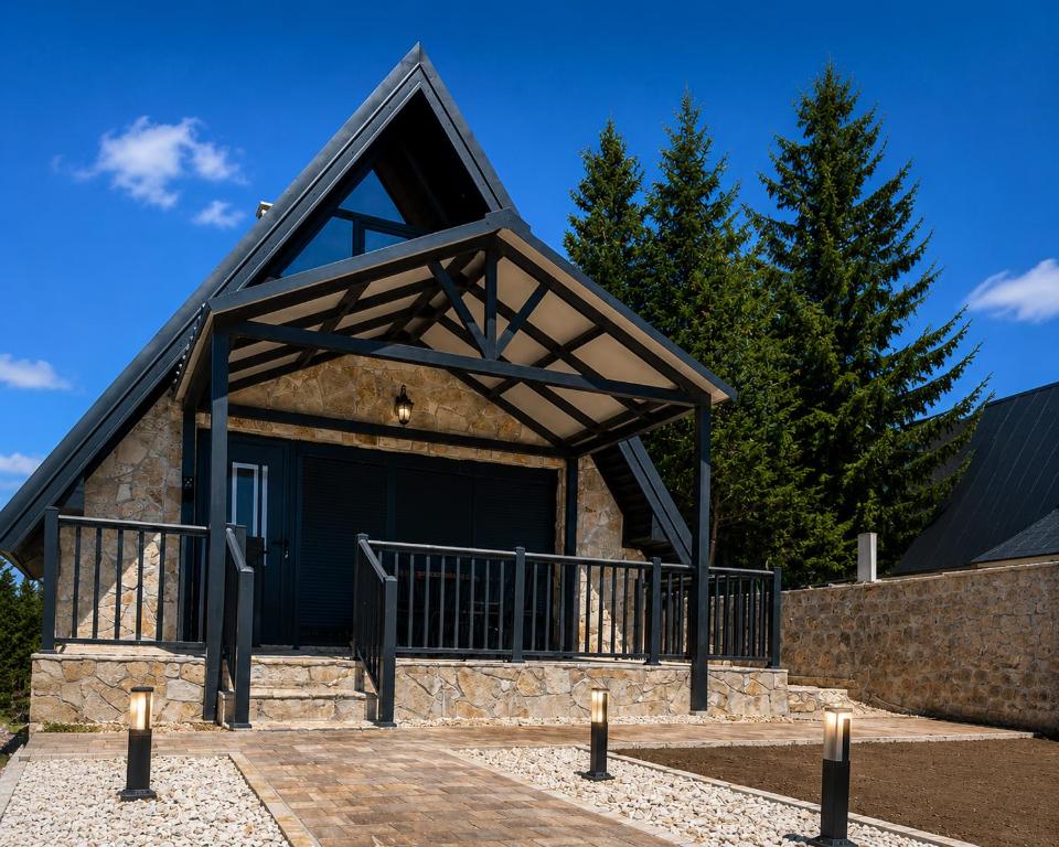 a building with a black garage with a roof at Mountain Whisper in Žabljak