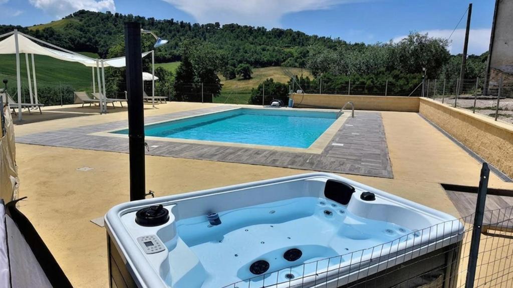 a bath tub sitting next to a swimming pool at Agriturismo La Terrazza in Valfabbrica