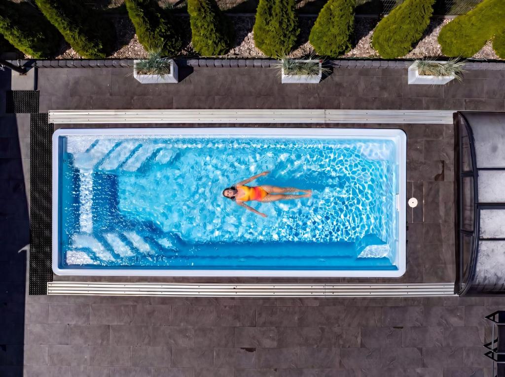 an overhead view of a person swimming in a pool at Loox Ostrovo- Boutique House-noclegi nad morzem in Ostrowo