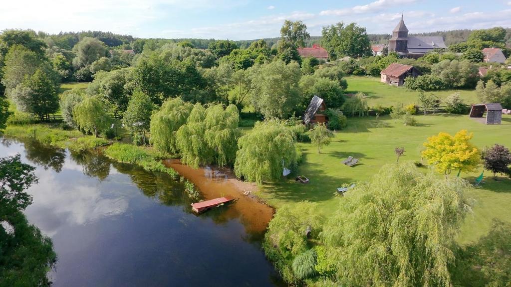 an aerial view of a river with trees and houses at Domki nad rzeką Ełk in Prostki