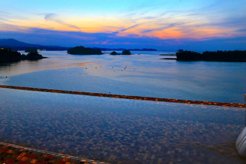 a view of a body of water at sunset at Uminoyasuragi Hotel Ryugu in Kami Amakusa