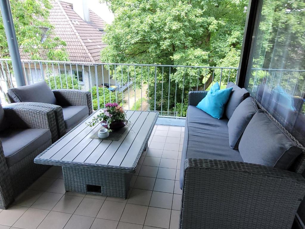 a patio with couches and a coffee table on a balcony at Apartment in Flensburg