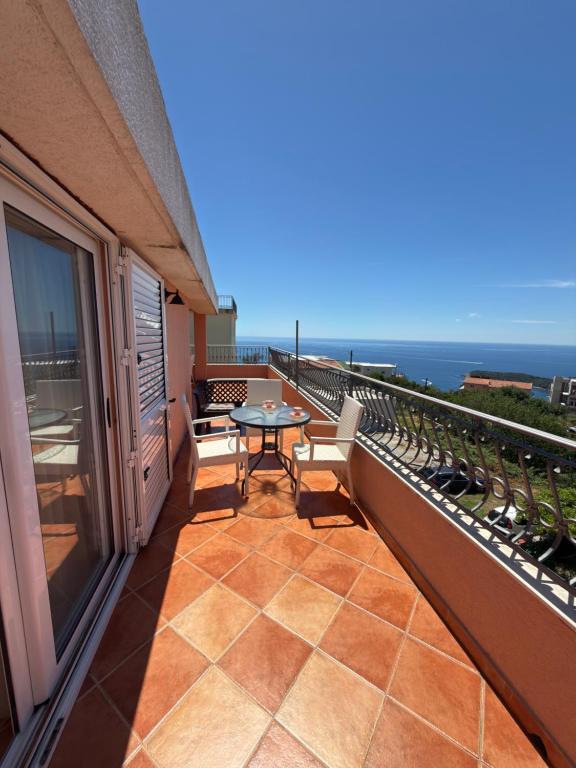 a balcony with a table and a view of the ocean at Alexandra in Prijevor