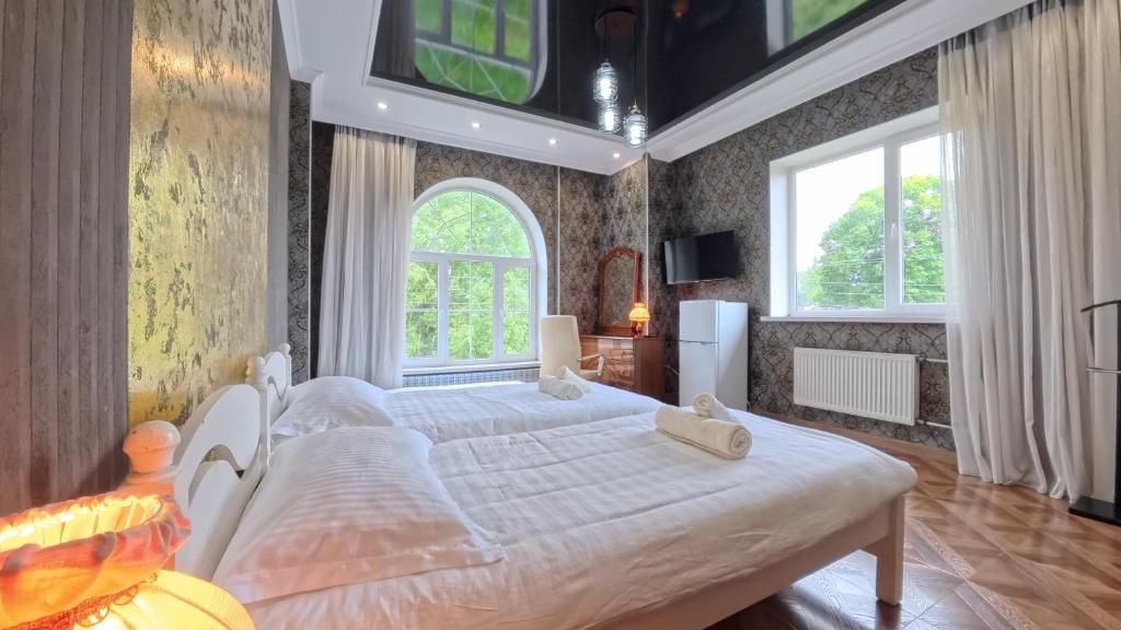 a bedroom with a large bed and a large window at ESAL House in Karakol