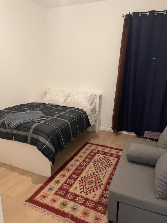 a bedroom with a bed and a rug and a couch at Jana holiday in Paris in Arcueil