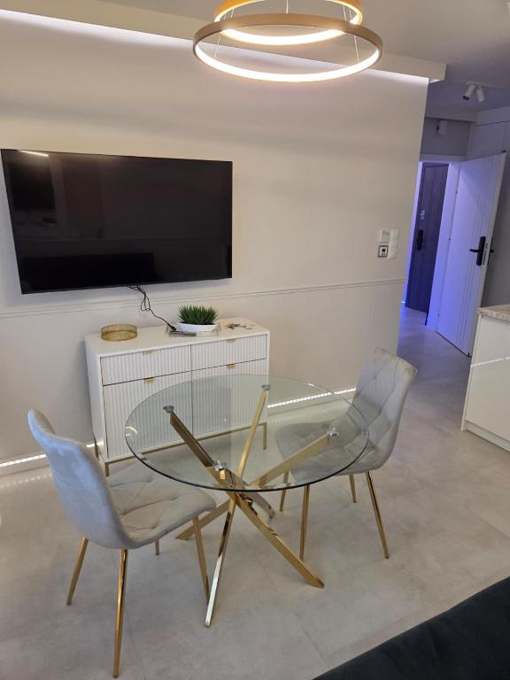 a dining room with a glass table and two chairs at GOLDEN HAUS Opole - Miss Gold & Mini Lux in Opole