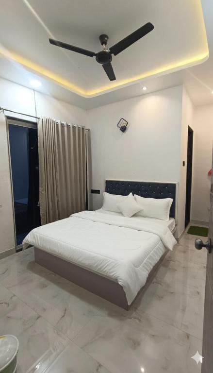 a bedroom with a large white bed with a ceiling at The Hilltop inn in Kelghar