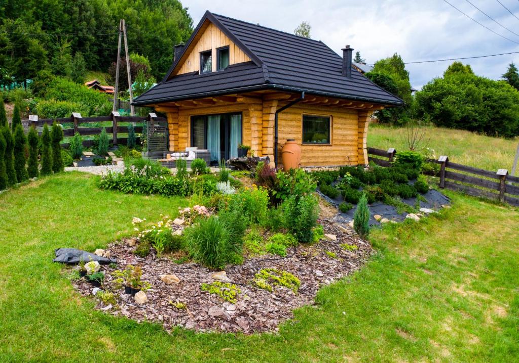 a small house with a garden in the yard at MamChwilkeHome in Istebna