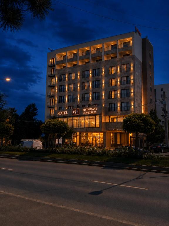 a hotel building with lights on in the night at In Grand Hotel & SPA in Bucharest