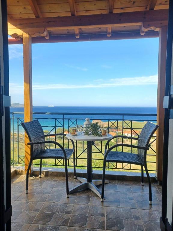 a table and chairs on a balcony with a view of the ocean at Studios Edem in Agios Ioannis Kaspaka