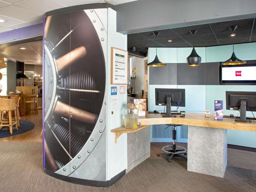 an office with a reception desk and a refrigerator at ibis Salon de Provence in Salon-de-Provence
