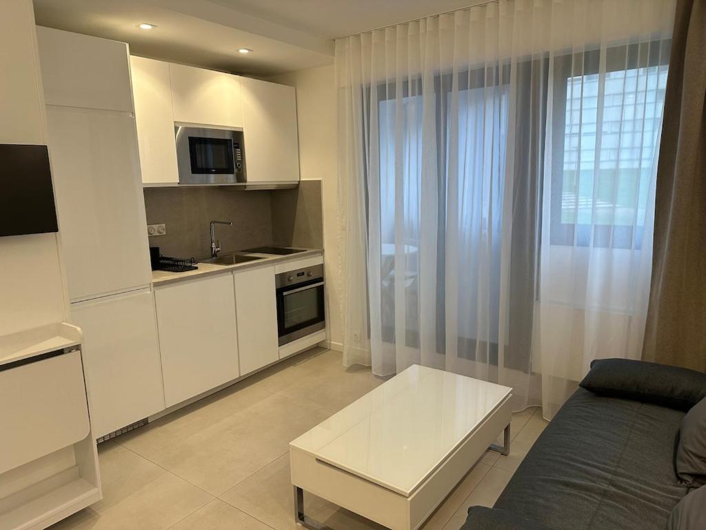 a kitchen with a couch and a table in a room at Studio du Lac in Créteil