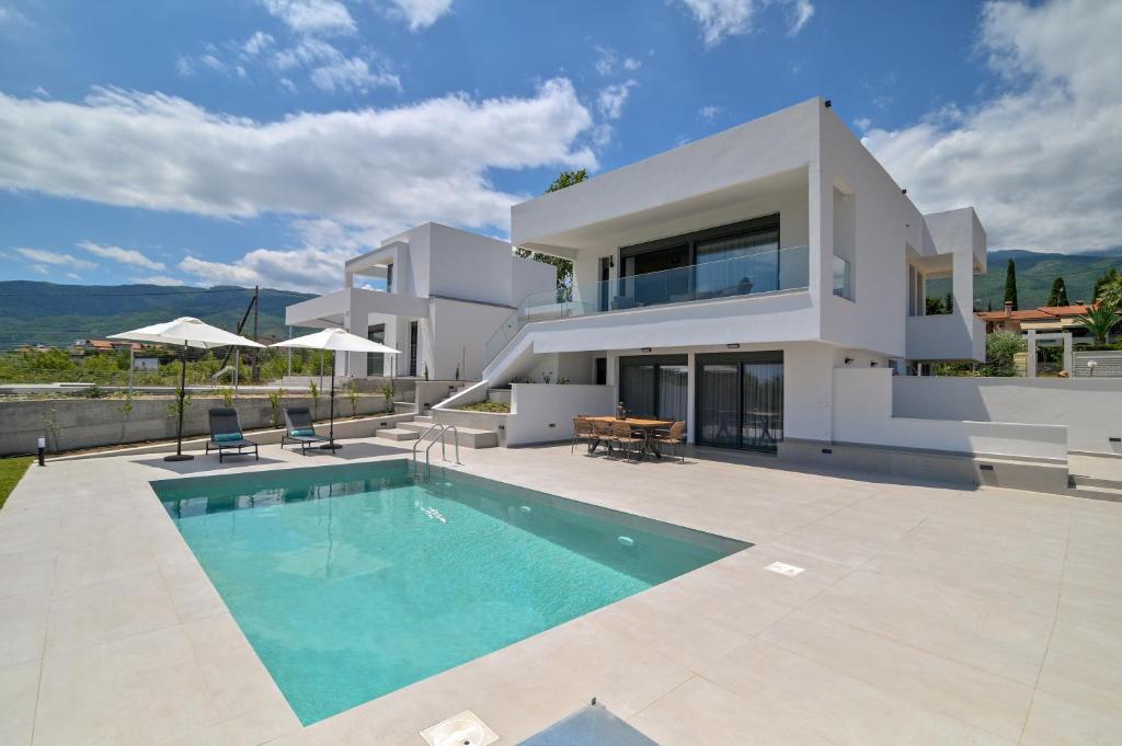 a villa with a swimming pool and a house at Apex Premium Living in Leptokarya