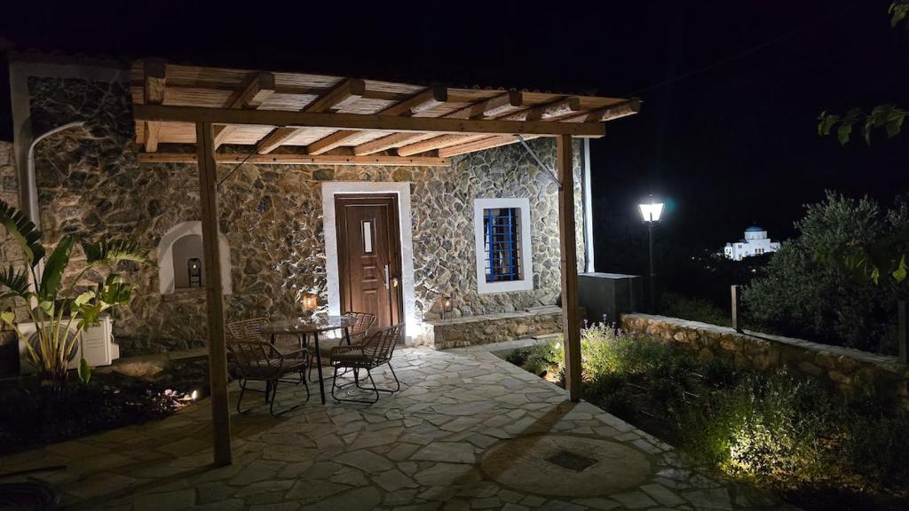 a patio at night with a table and chairs at Stay In Zia in Asfendioú