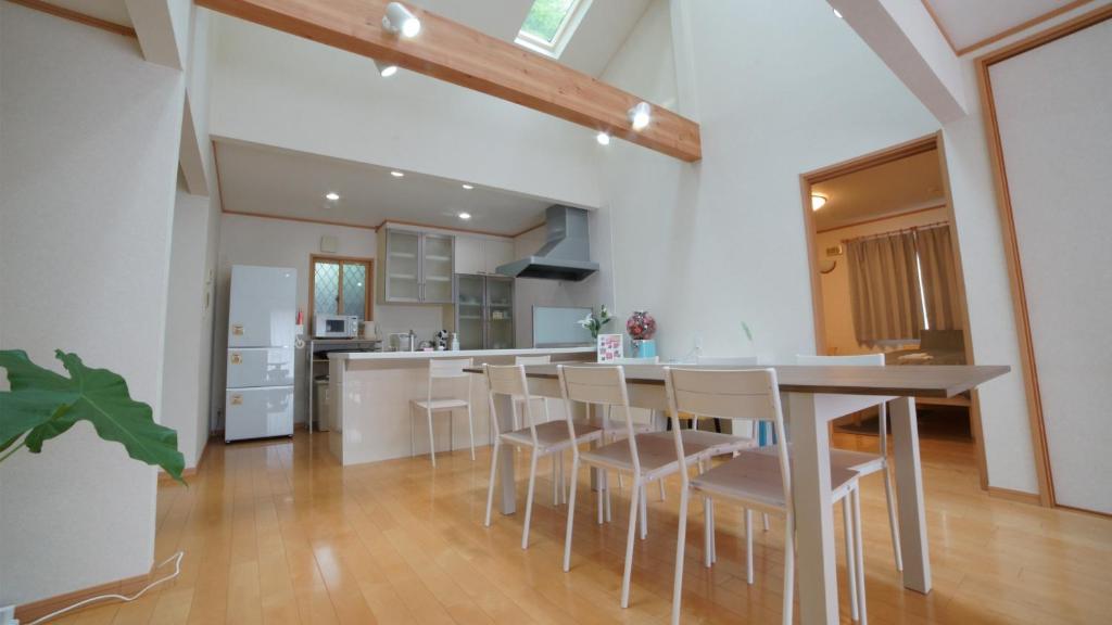 a kitchen with a table and chairs in a room at maison de plum in Nasushiobara