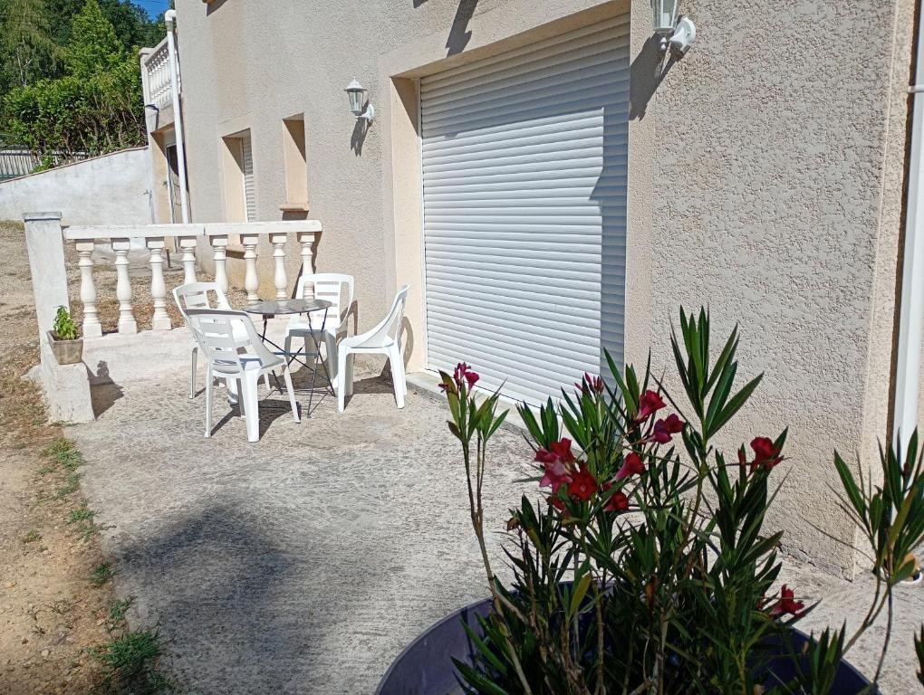 a patio with a table and chairs next to a building at Apartment 65 m2 SE Rez de Jardin 2 chambres in Varetz
