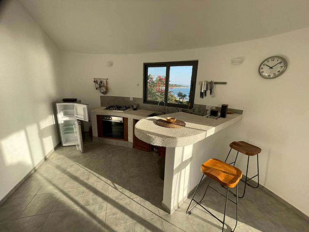 a kitchen with a counter and a clock on the wall at Les Cases Rouges in Kaolack