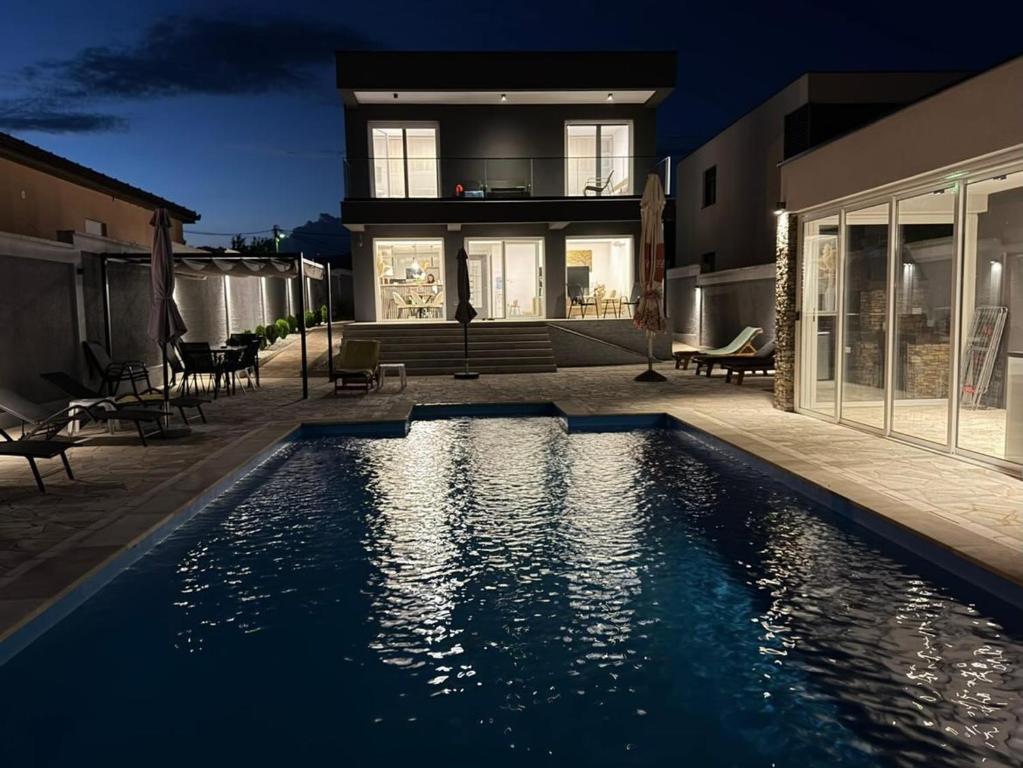 a house with a swimming pool in front of a house at Villa Verona in Mostar