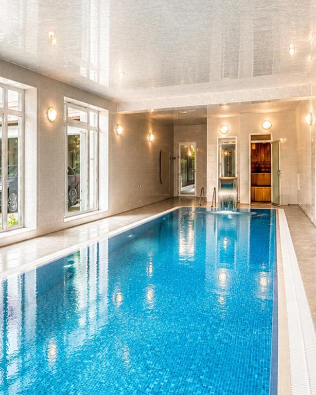 a large swimming pool with blue water in a building at Bilgah Coast Villa in Baku