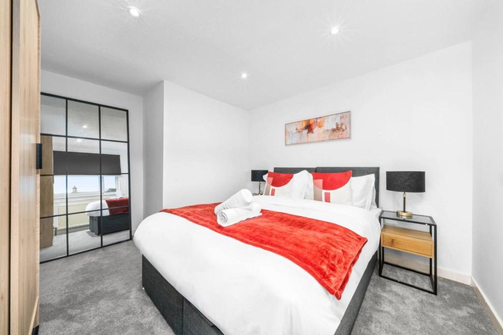 a bedroom with a large white bed with red pillows at 3-Bed Home in East Kilbride Ideal for Contractors & Longer Stays from Voyage Collection in East Kilbride