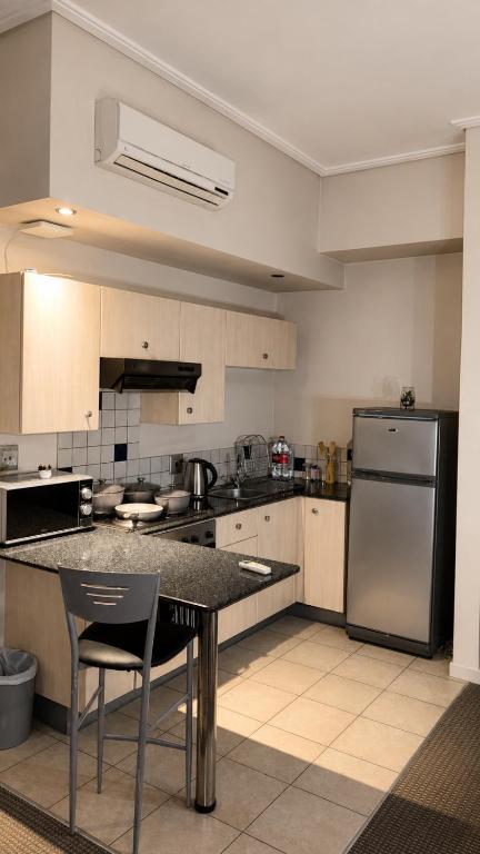 a kitchen with a table and a stainless steel refrigerator at Mapungubwe Hotel in Johannesburg