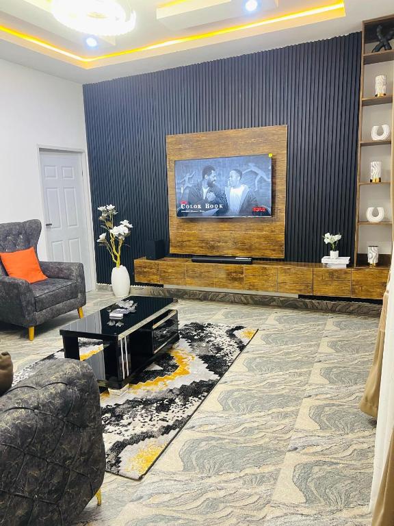 a living room with a couch and a tv at DAS Apartments Lugbe in Abuja