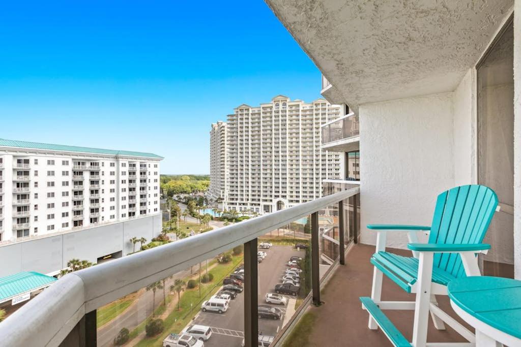 a balcony with blue chairs and a view of a city at Gorgeous and well appointed efficiency with shared pool and beach access in Destin
