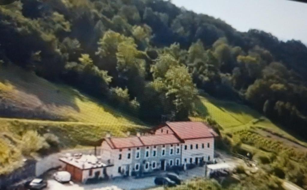 an aerial view of a large house in a mountain at Agriturismo La Casa Nei Boschi in Colderù