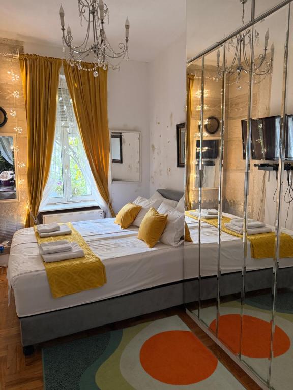 a bedroom with a large bed and a chandelier at Lux Beba Pancevo in Pančevo