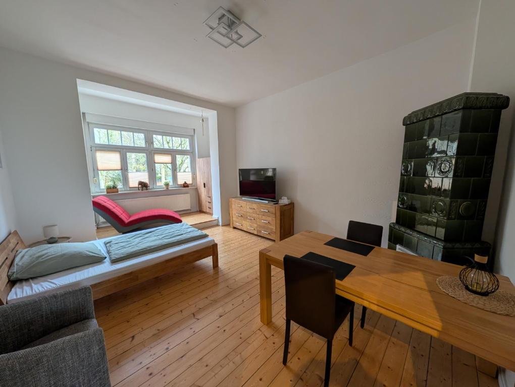a living room with a bed and a table at Zimmervermietung an der Bebra in Sondershausen