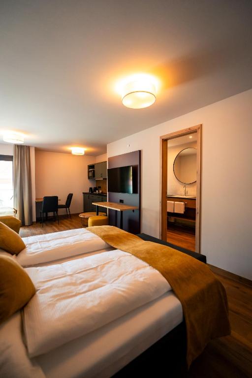 a hotel room with two beds and a mirror at Adler Apartments in Bach
