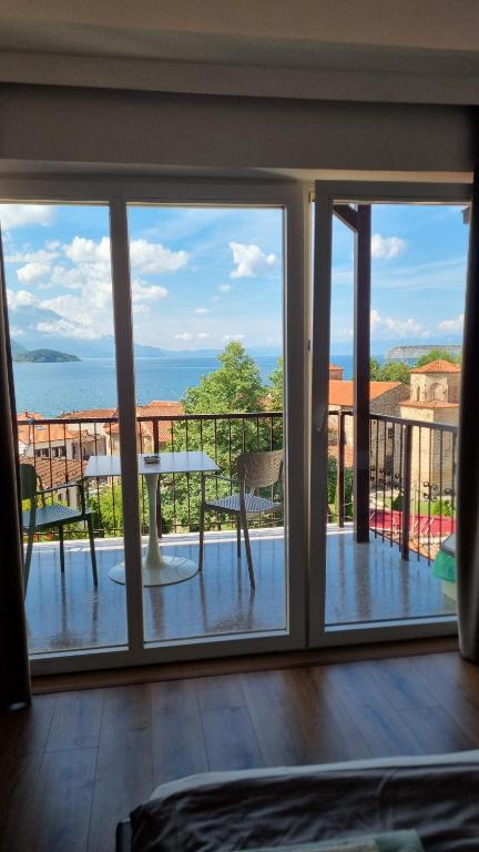 a balcony with a table and a view of the ocean at Lukanov Apartments - Lake view in Ohrid