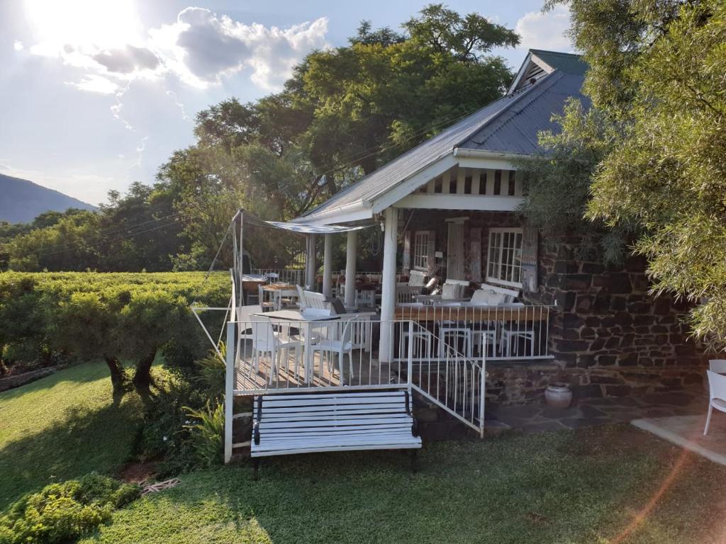 a house with a porch with a table and chairs at Guesthouse 1921 in Hartbeespoort