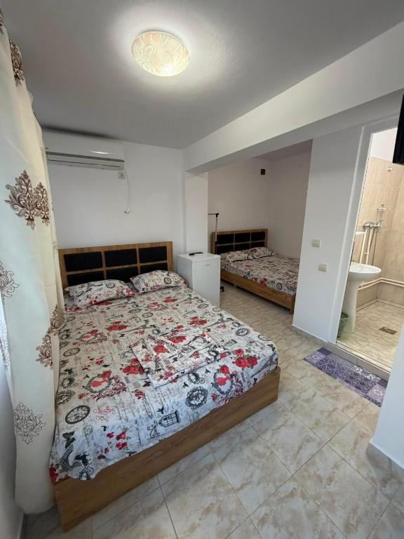 a bedroom with a bed and a bathroom with a sink at Casa Raul Eforie Sud in Eforie Sud