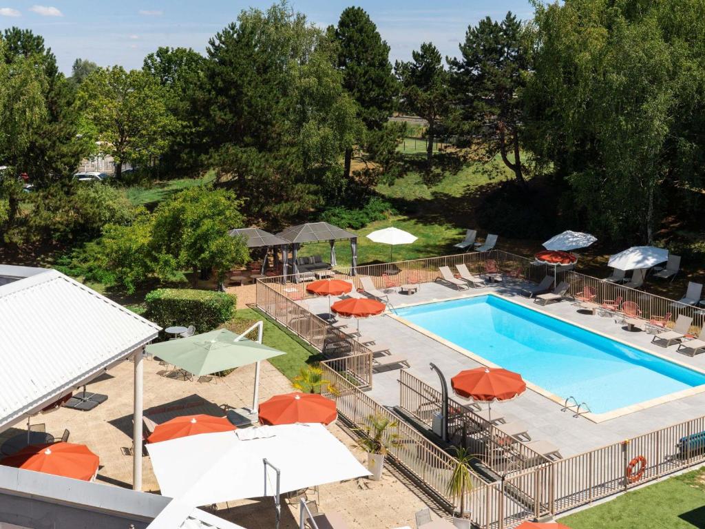 an overhead view of a swimming pool with umbrellas at Mercure Tours Nord in Tours