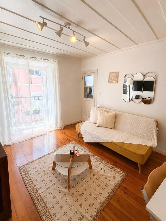 a living room with a couch and a coffee table at Central Lisbon Apartment Santos Walk to Cais do Sodré in Lisbon
