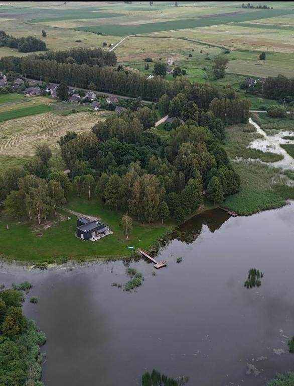 an aerial view of a house on an island in a lake at Sodyba Biruta in Tautrimai
