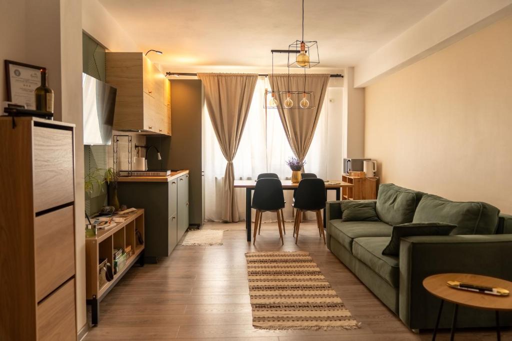 ein Wohnzimmer mit einer grünen Couch und einem Tisch in der Unterkunft CITADEL VIEW in Târgu Neamţ