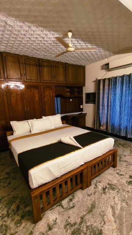 a bedroom with a large bed with a ceiling at THANAL homes in Kollam
