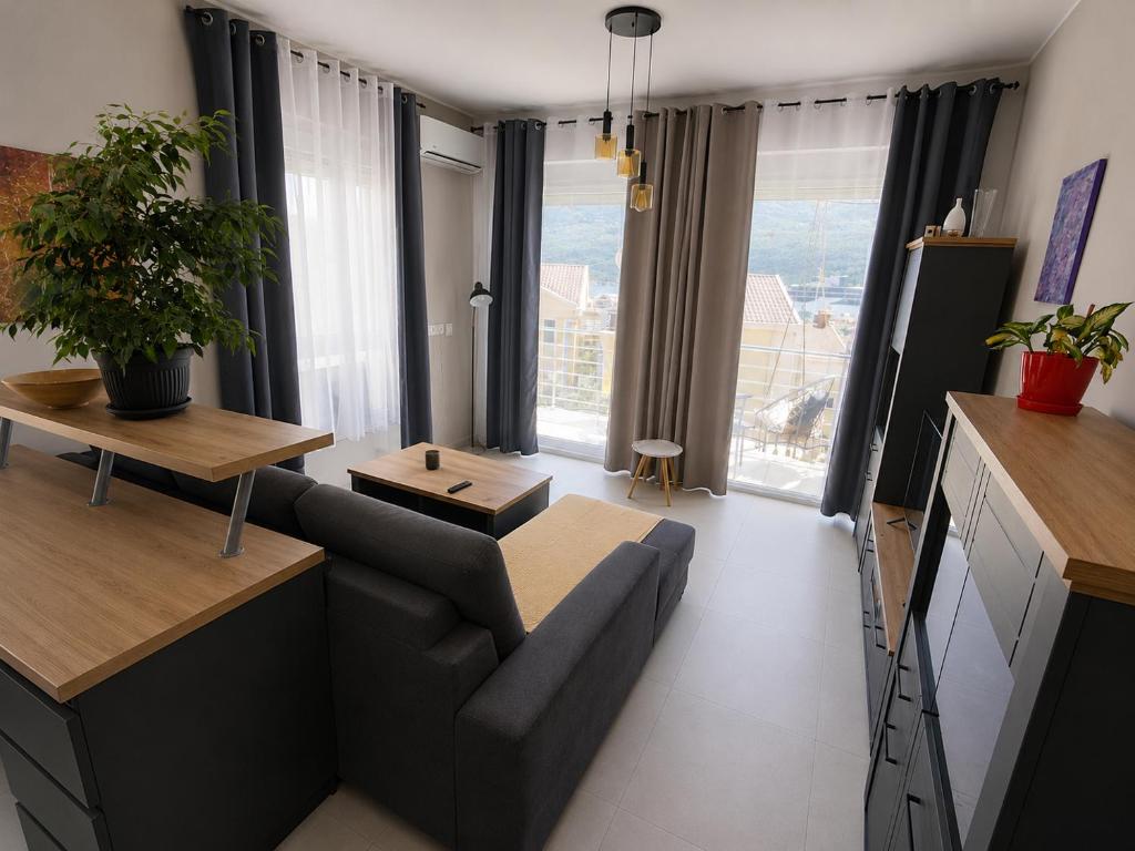 a living room with a couch and a table at LouAdria Apartments in Đenovići