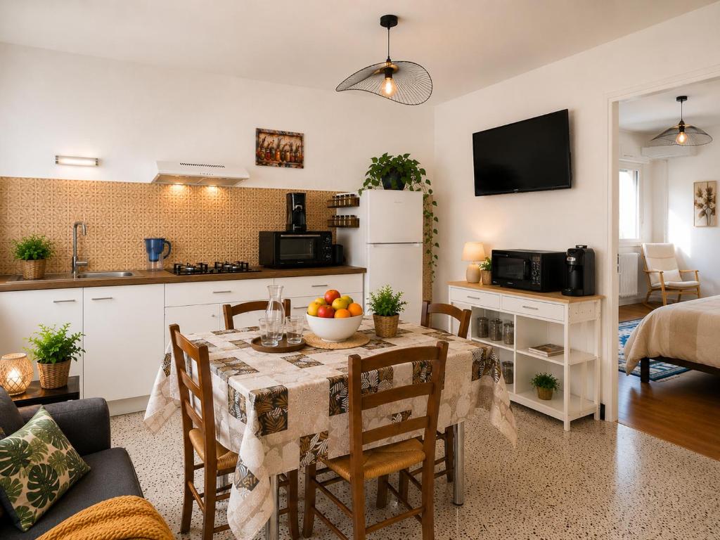 a kitchen and a dining room with a table and chairs at Les Lavandes de Vals in Vals-les-Bains