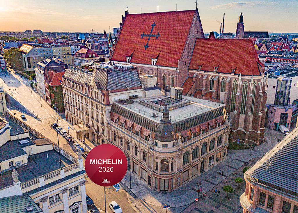 an old building with a cross on top of it at Hotel Monopol in Wrocław